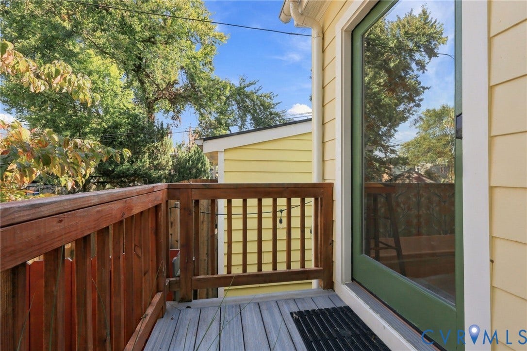 Wood deck with a solid wood railing and a full-light door