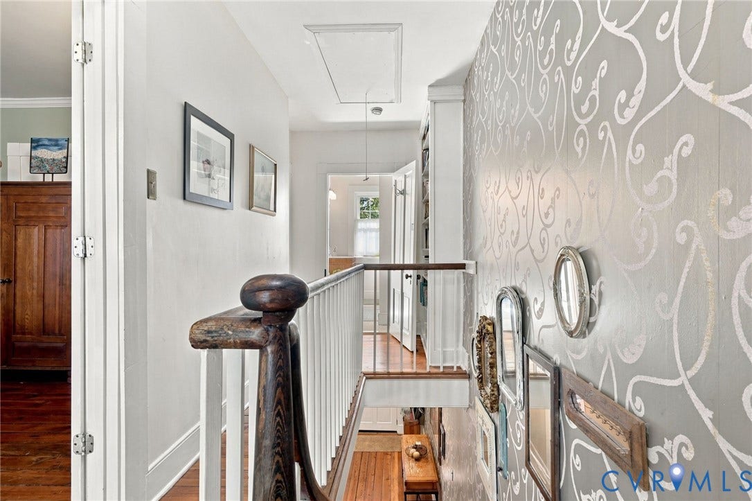 Hardwood flooring, painted walls, white trim, and a patterned accent wall