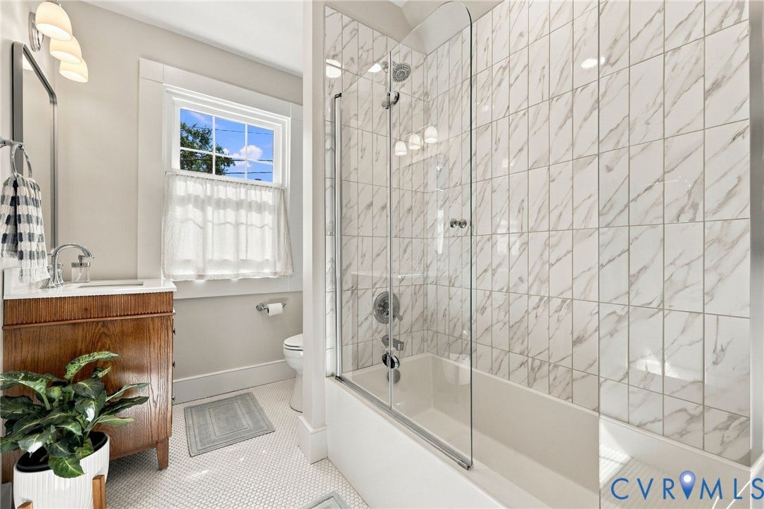 Wood-finish vanity with a white countertop and polished chrome faucet