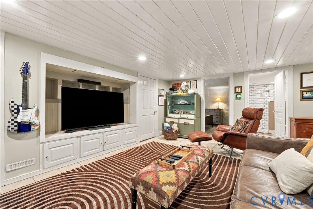 Built-in media console with storage, recessed lighting, planked ceiling, tile flooring, and multiple doorways
