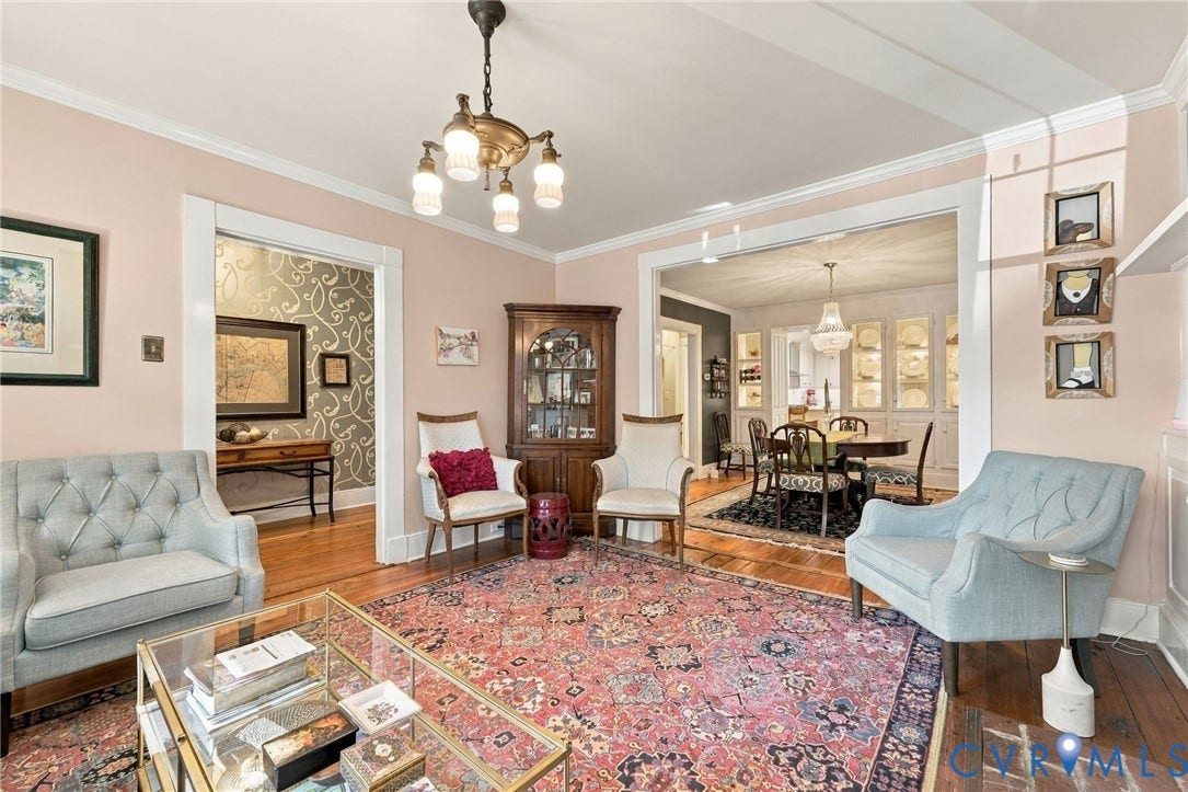 Wood-finish flooring throughout, crown molding, and a chandelier with glass shades