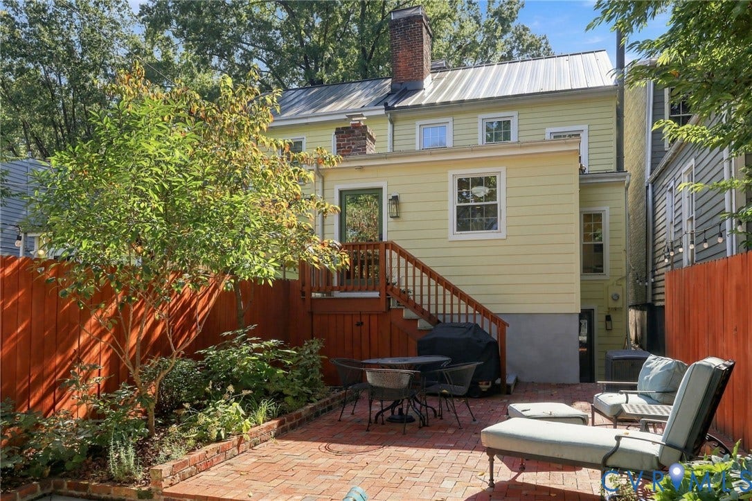 Rear exterior featuring a brick patio and wood privacy fencing