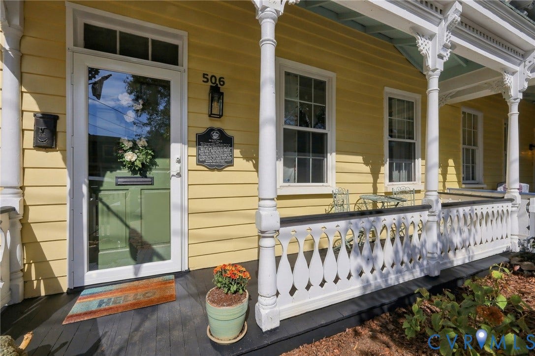 Yellow horizontal siding exterior with a traditional green entry door