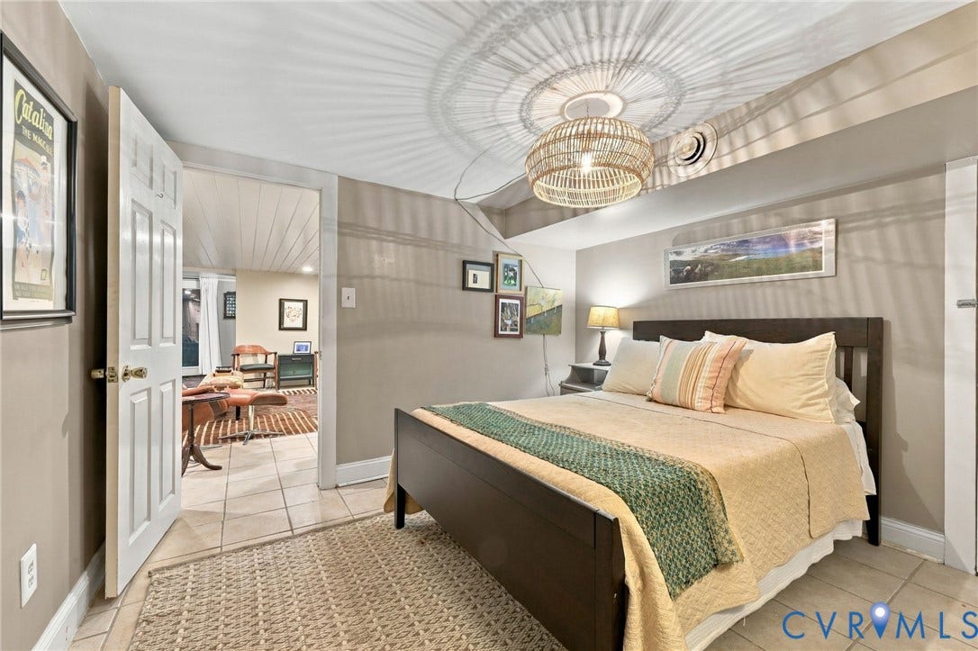 Basement bedroom with recessed ceiling with shiplap detail, tile flooring, and a contemporary woven pendant light fixture