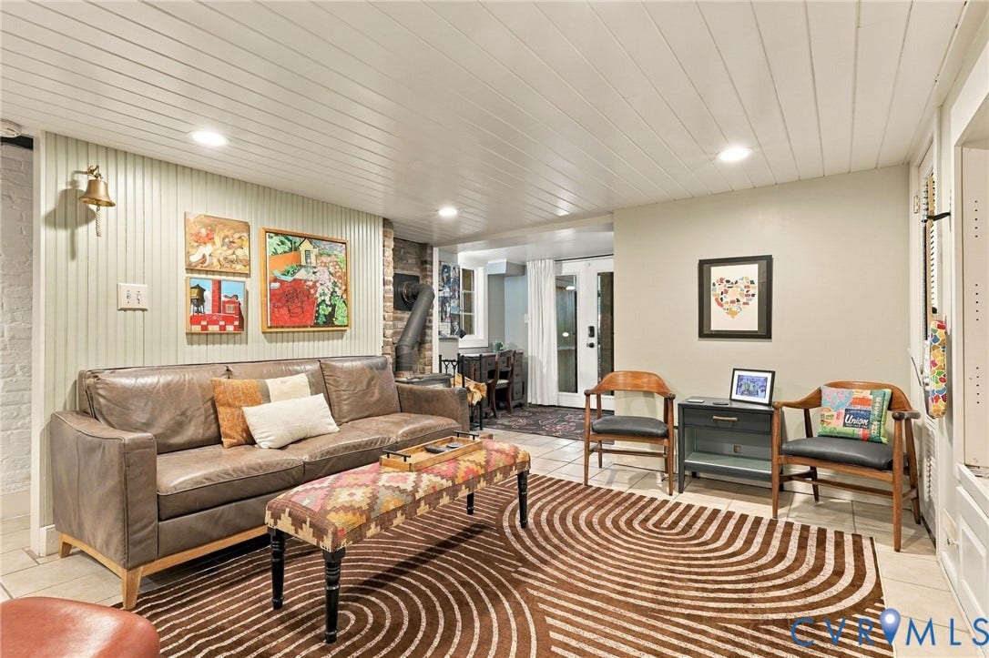 White paneled ceiling, recessed lighting, beadboard wall accents, exposed brick column, and light-toned tile flooring