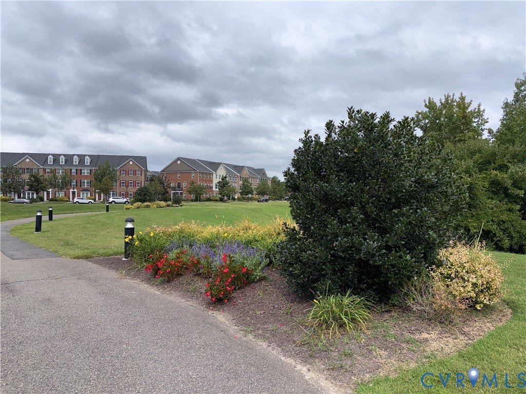 3931 Liesfeld Place, West Broad Village, Henrico, VA 23060 Landscaped grounds featuring a paved pathway, decorative bollard lighting, and a variety of mature shrubs and colorful plantings