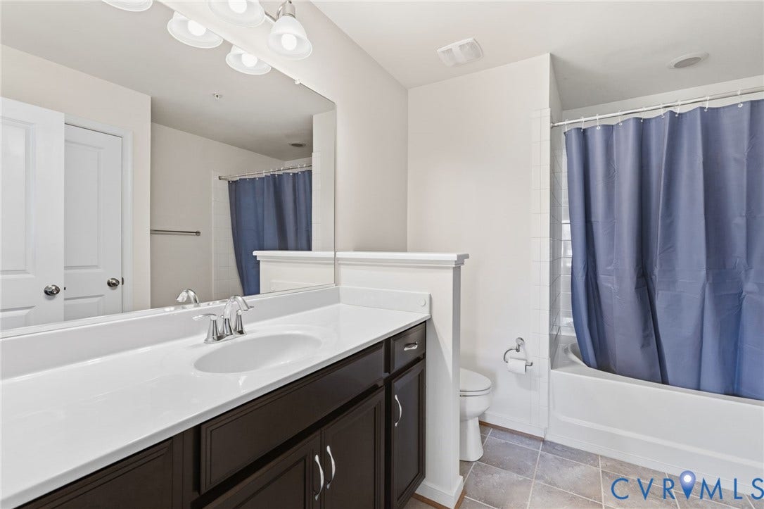 3931 Liesfeld Place, West Broad Village, Henrico, VA 23060 Bathroom featuring a single vanity with dark wood-finish cabinetry, a white countertop with an integrated sink, a large wall mirror, and a shower-over-tub combination with white tile surround