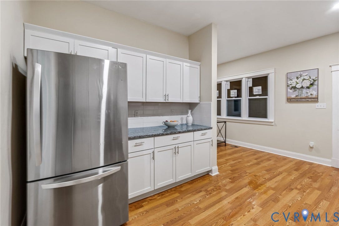 12105 Mathenay Drive, Mathenay, Chesterfield, VA 23831 Stainless steel refrigerator, white shaker-style cabinetry, dark speckled countertops, gray subway tile backsplash, and wood-finish flooring