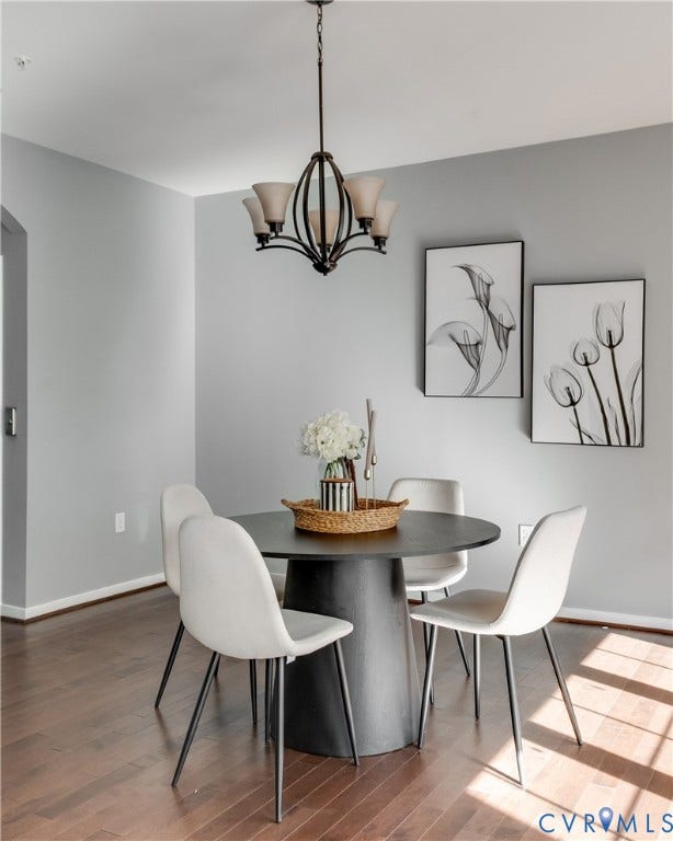 Wood-finish flooring, recessed lighting, and a five-light chandelier with frosted glass shades