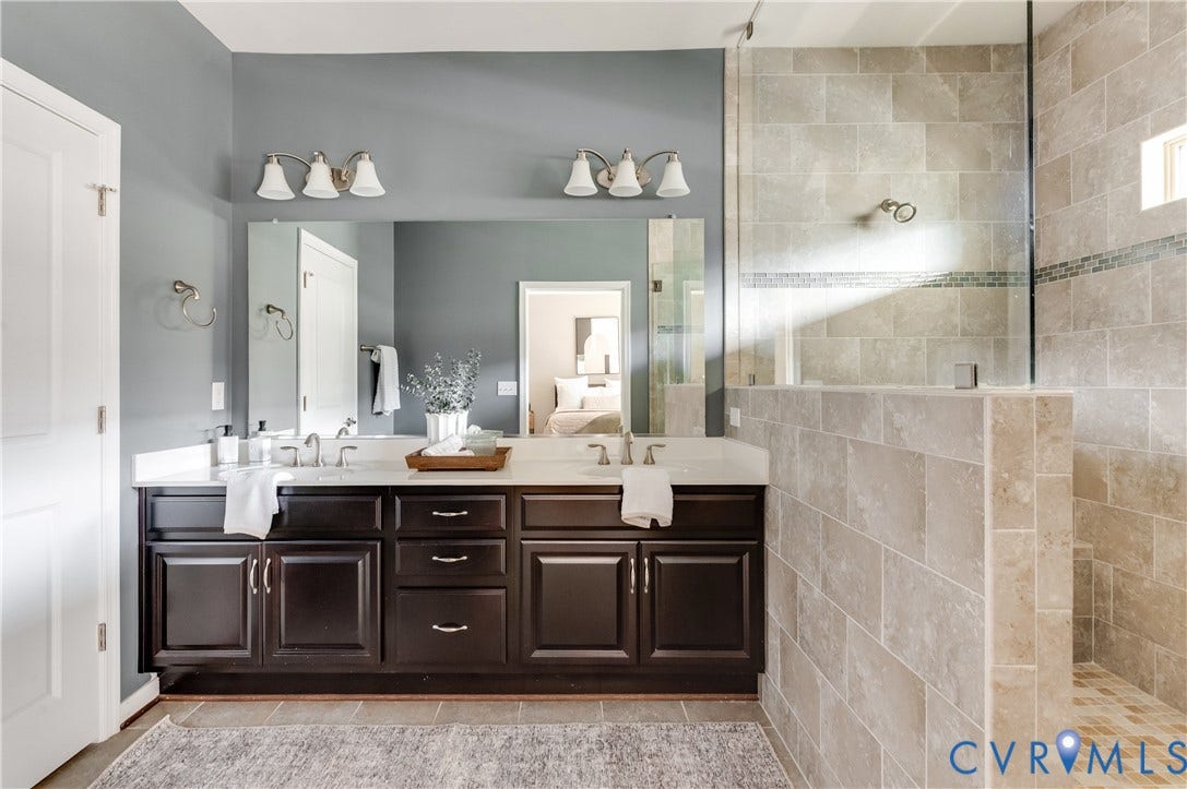 Dual vanity with under-mount sinks, dark wood-finish cabinetry, and brushed nickel fixtures