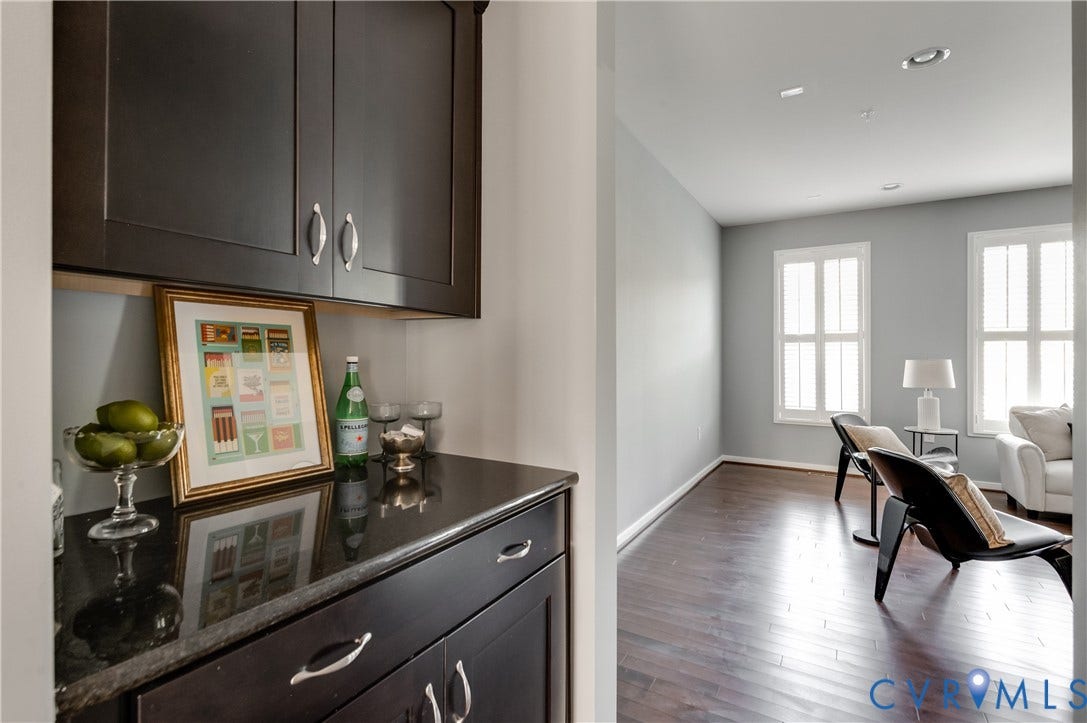 Built-in cabinetry with dark finish, polished dark countertop, dark wood-finish flooring, and recessed lighting