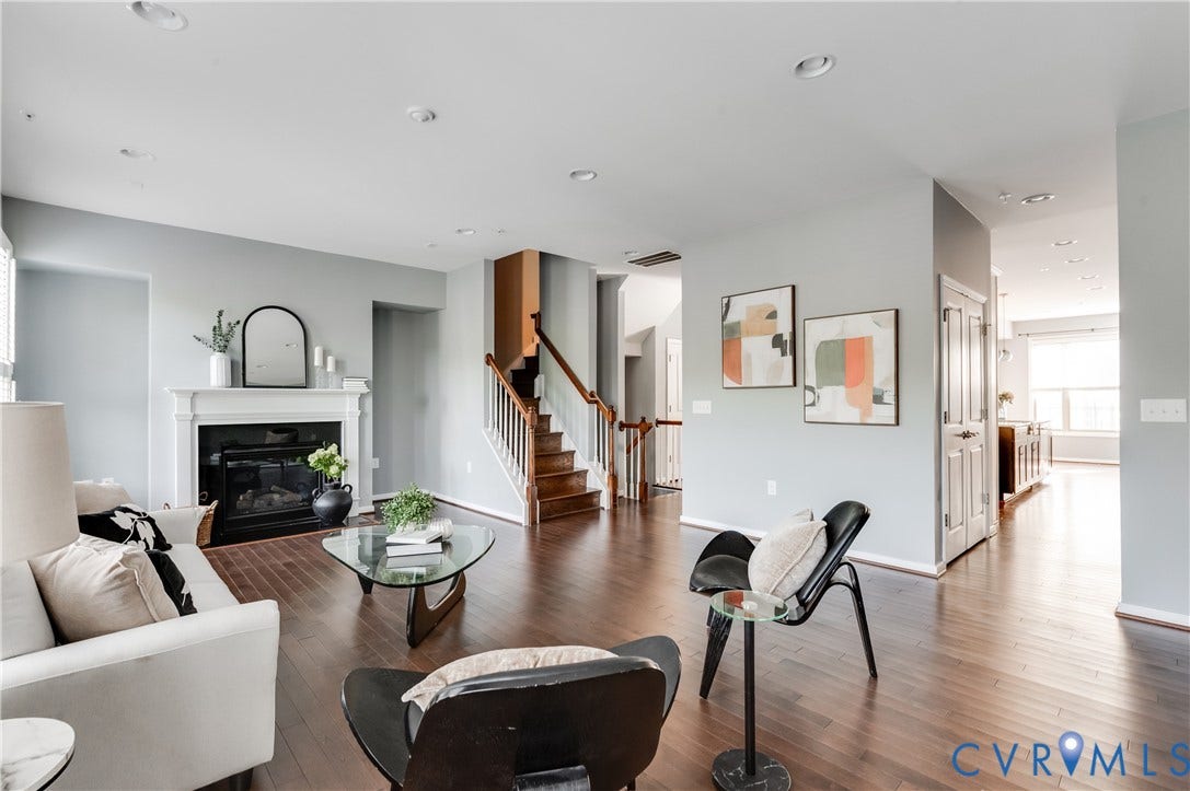 Hardwood-finish flooring, recessed lighting, and a white fireplace with a mantel