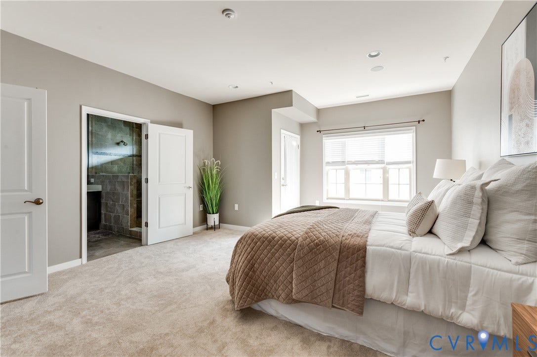 Plush carpeting throughout, recessed lighting, and a large window with blinds