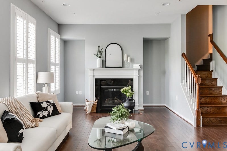 Wood-finish flooring throughout, featuring a fireplace with a classic white mantel