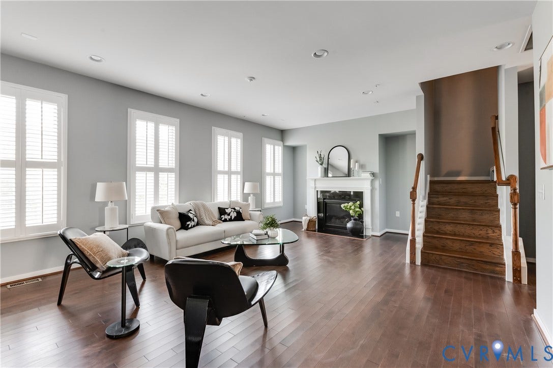 Hardwood flooring, recessed lighting, white window shutters, and a fireplace with a classic mantel