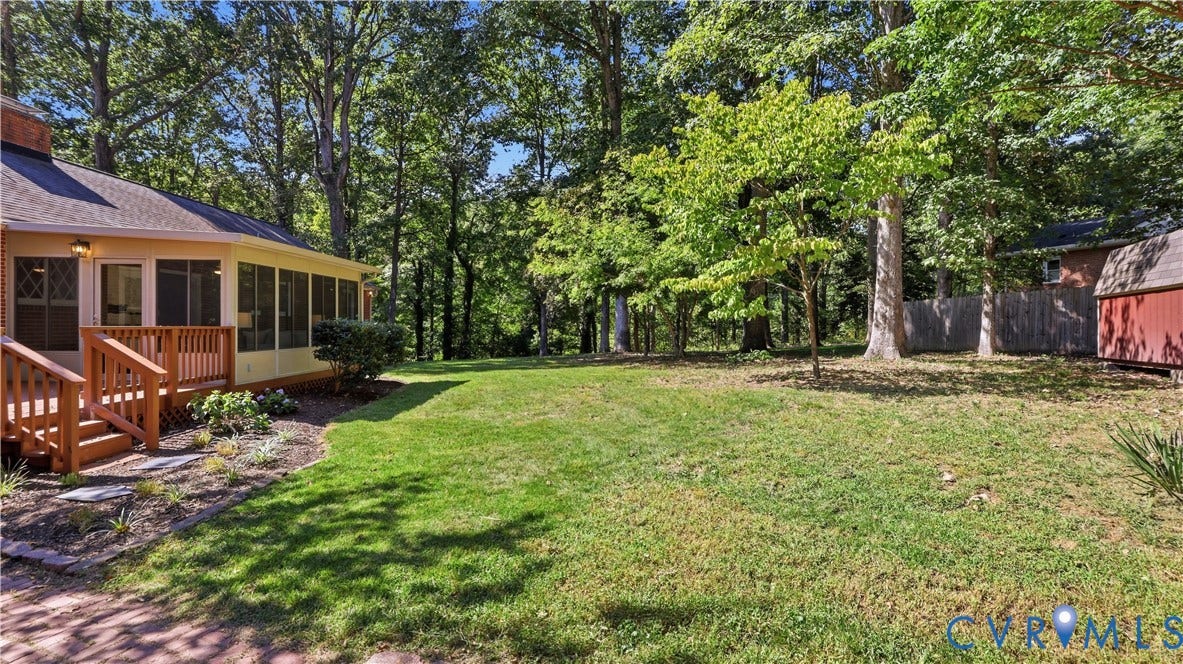 Expansive lawn with mature trees and a screened porch