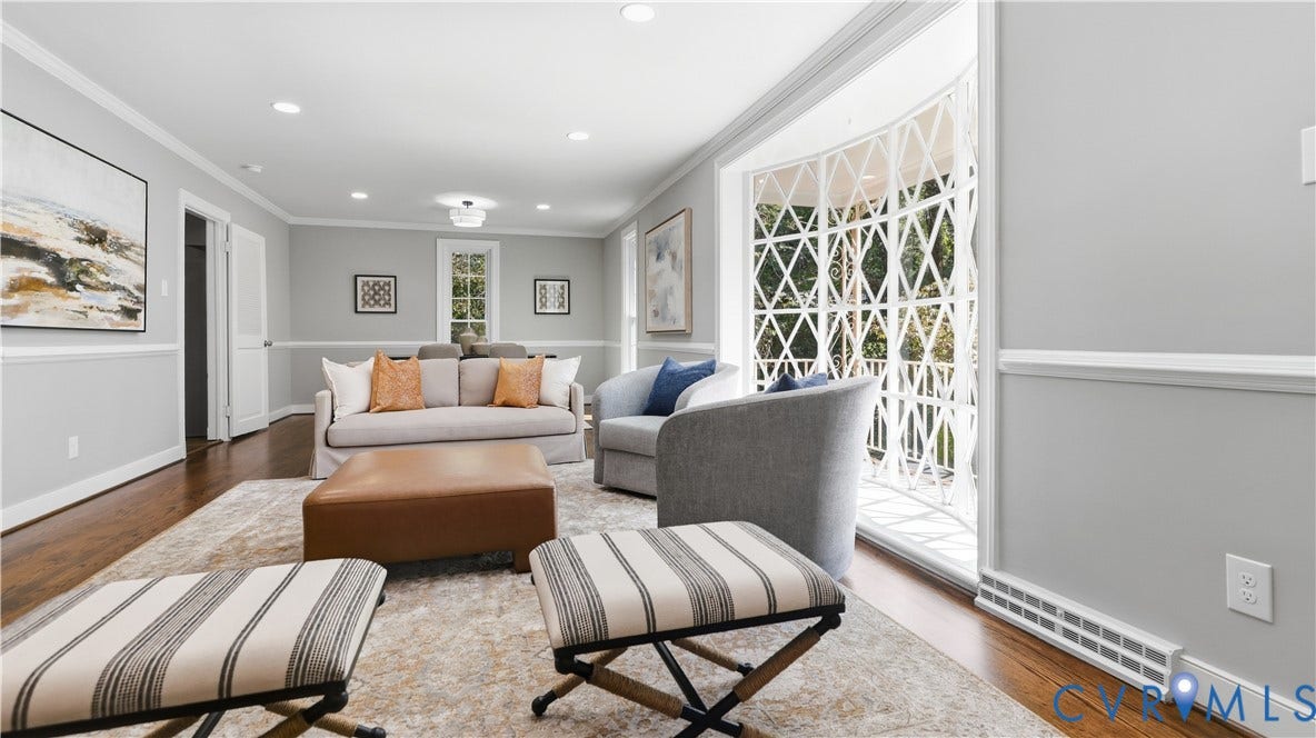 Hardwood flooring, recessed lighting, crown molding, chair rail molding, and a bay window with decorative grille