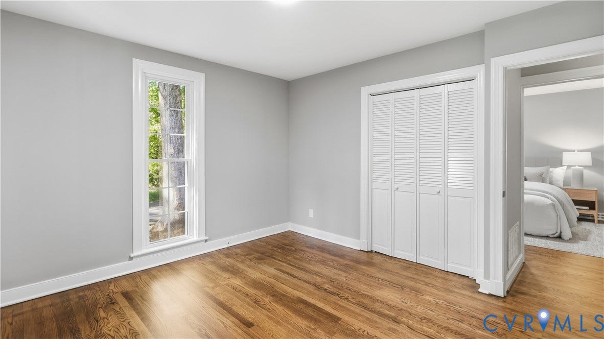 Wood-finish flooring, white trim, single window, louvered bi-fold closet doors, recessed ceiling light