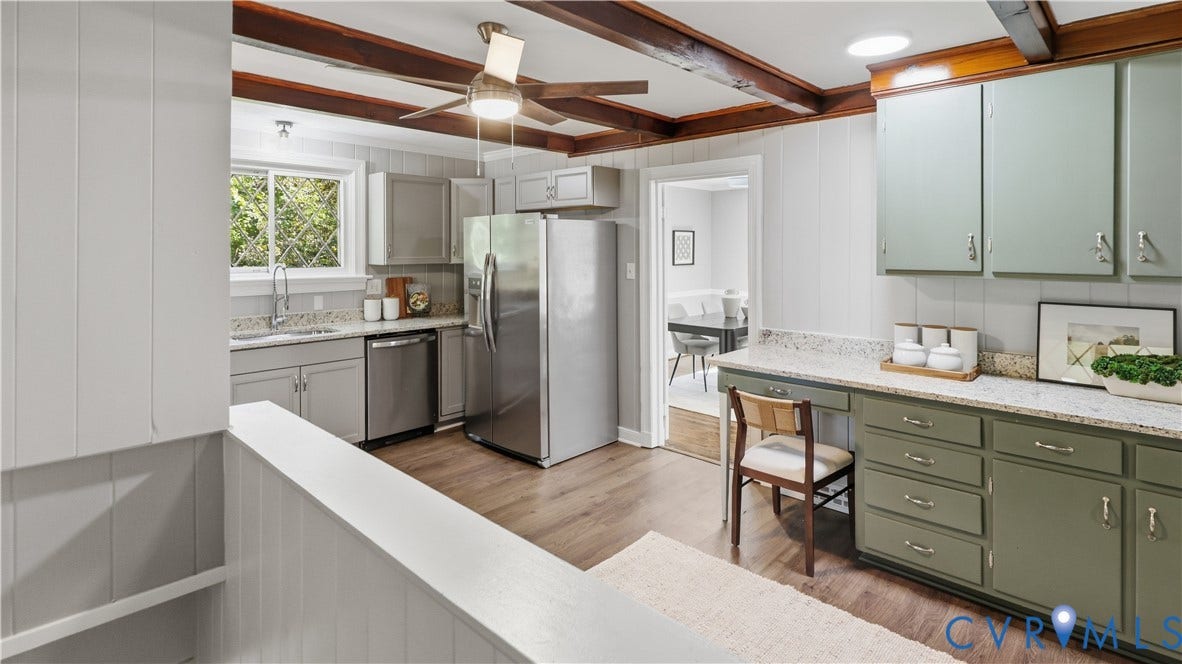 Kitchen featuring wood-finish flooring, exposed wood beams, stainless steel appliances, and a ceiling fan