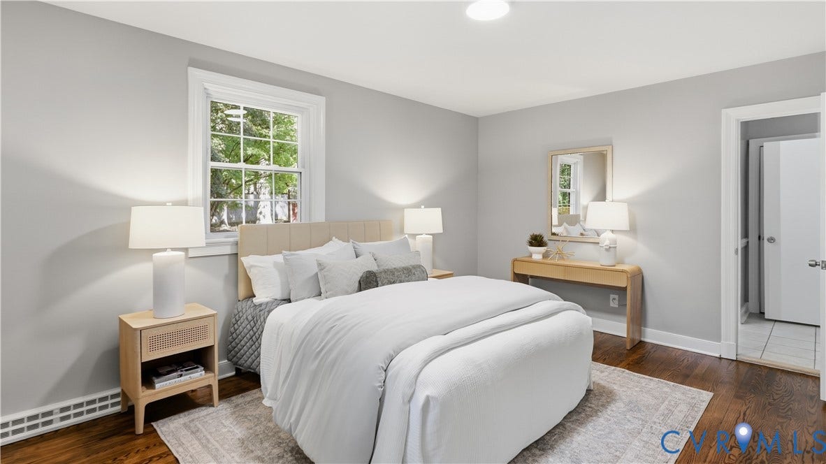 Hardwood-style flooring, neutral wall tones, window with natural light, and a built-in overhead light fixture