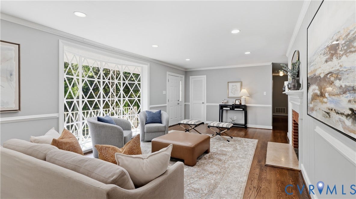 Recessed lighting, wood-finish flooring, white crown molding, white chair rail, and a brick-lined fireplace with a white mantel