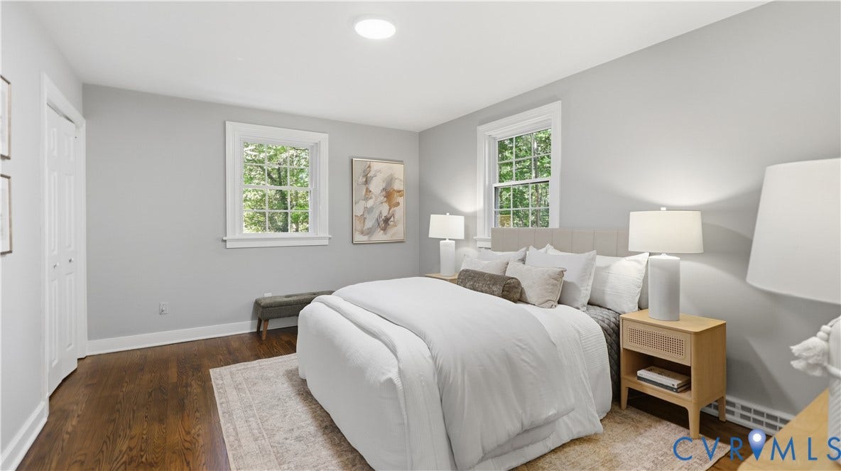 Hardwood-finish flooring, light gray wall paint, two windows with white trim, built-in closet with bi-fold doors, and a recessed ceiling light