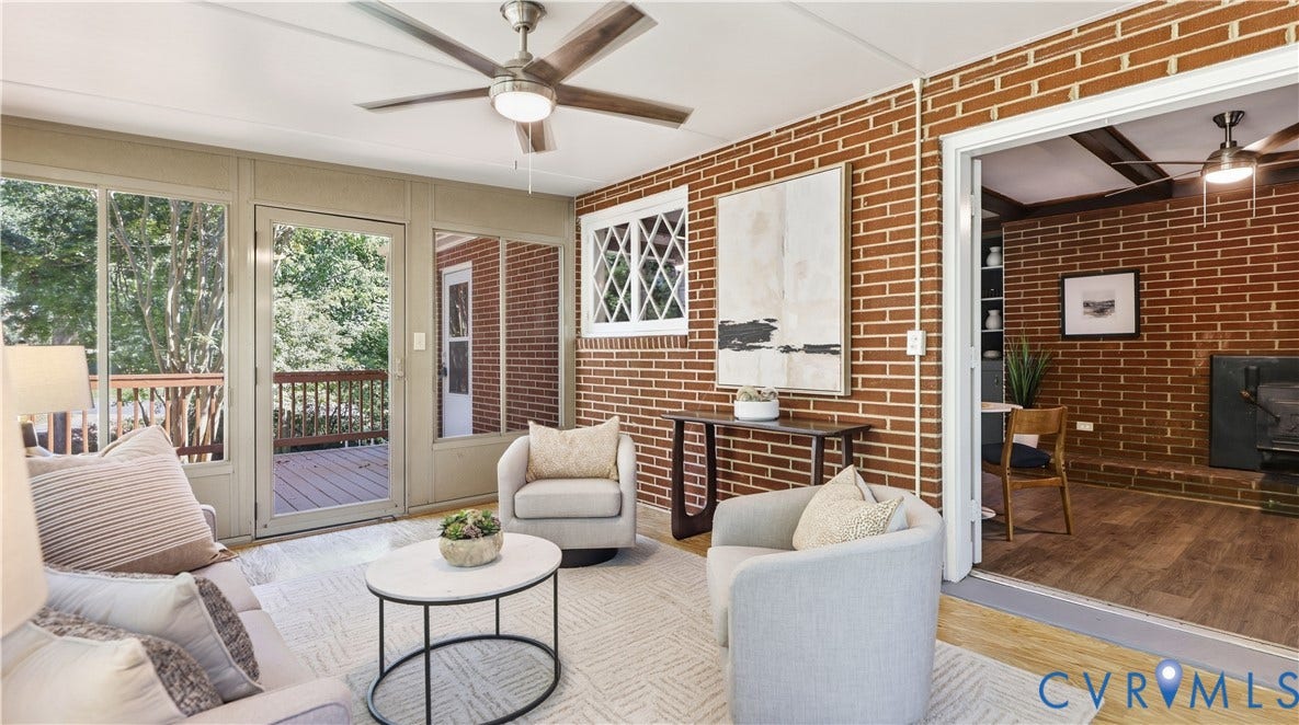 Sunroom featuring brick walls, wood-finish flooring, a ceiling fan with integrated lighting, and direct access to an exterior deck