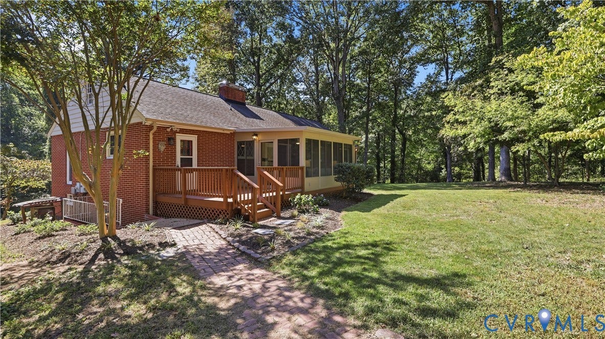 Brick exterior, wood deck, screened porch, mature trees, and an expansive lawn