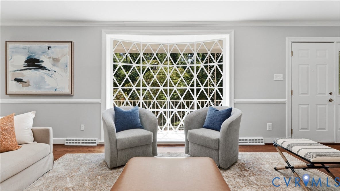 Hardwood flooring, decorative window security bars, crown molding, chair rail molding, and a paneled entry door