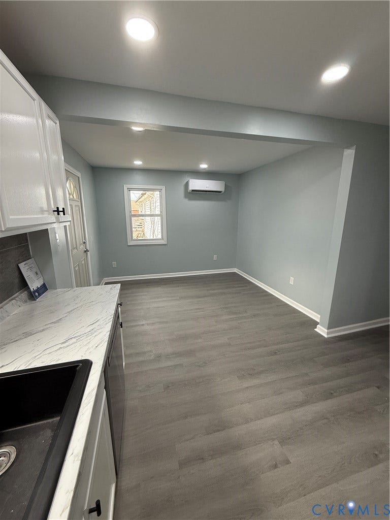 129 S Old Church Street, Petersburg, VA 23803 Kitchen featuring dark wood-style flooring, recessed lighting, an AC wall unit, white cabinets, and baseboards