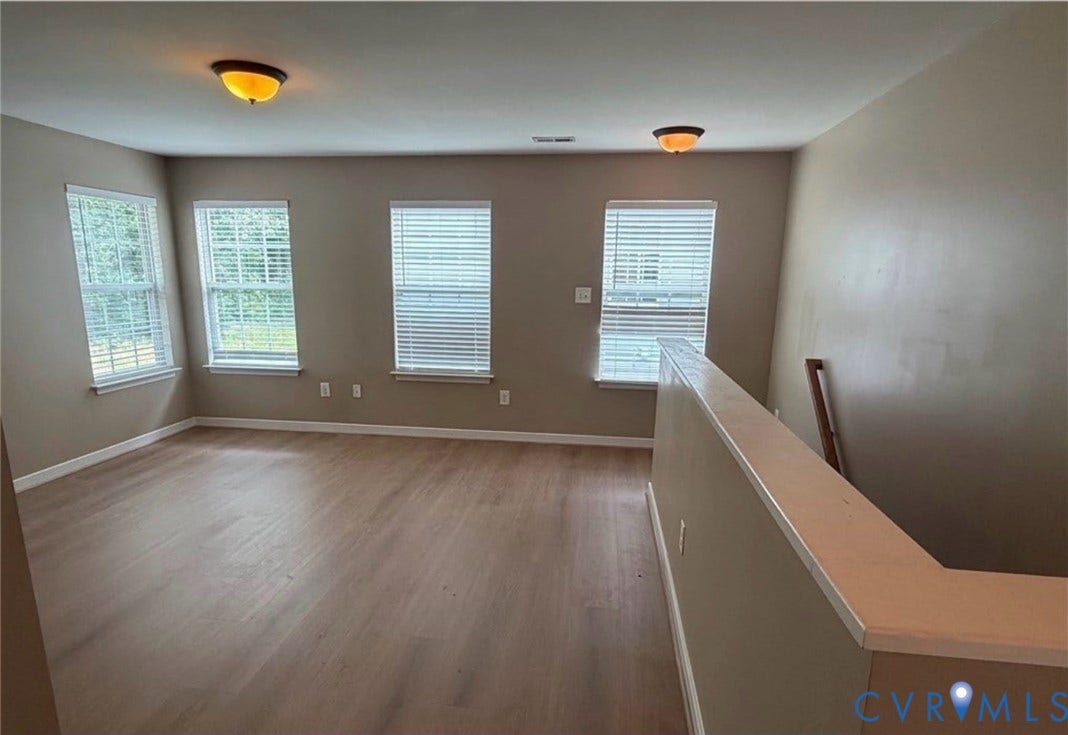 7319 Vicenzo Drive, Moseley, VA 23120 Expansive room featuring wood-finish flooring, three windows with white blinds, and two flush-mount ceiling lights
