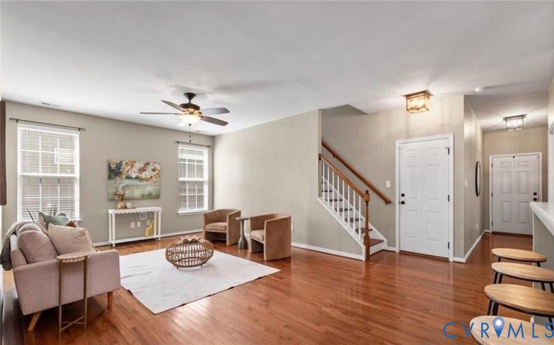 7319 Vicenzo Drive, Moseley, VA 23120 Hardwood flooring, two large windows with blinds, ceiling fan with integrated lighting, a staircase with wood handrails, and built-in lighting fixtures