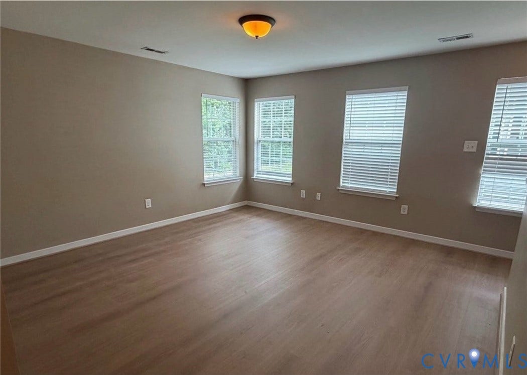 7319 Vicenzo Drive, Moseley, VA 23120 Expansive room featuring wood-finish flooring, multiple windows with blinds, neutral wall tones, and a ceiling-mounted light fixture
