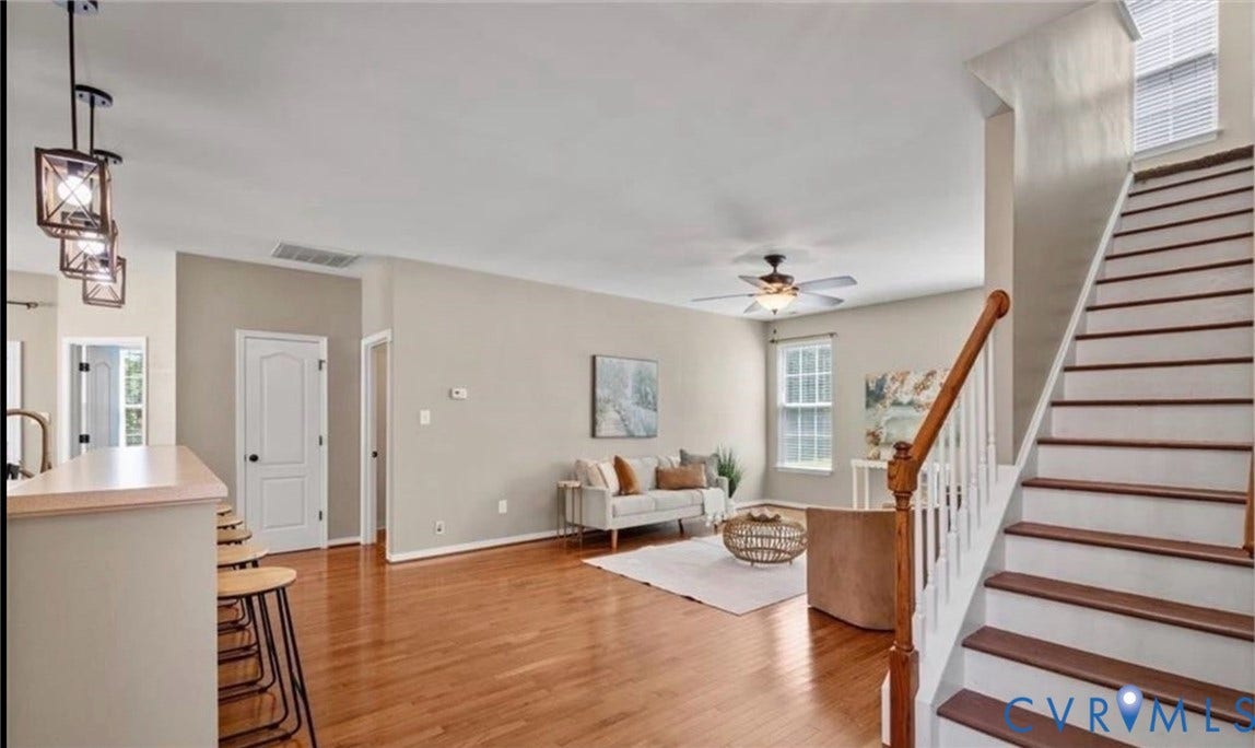 7319 Vicenzo Drive, Moseley, VA 23120 Hardwood flooring, painted walls, ceiling fan, natural light from windows, and a staircase with wood treads and a white balustrade