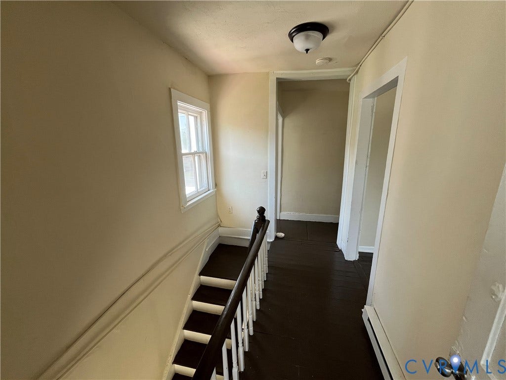 927 Farmer Street, Petersburg, VA 23803 Staircase with dark wood treads and white risers, illuminated by a window with white trim