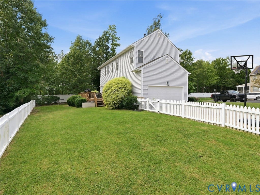 13925 Gorham Lane, Charter Colony, Midlothian, VA 23114 Expansive rear lawn featuring a white picket fence, a two-story residence with light gray siding, an attached garage, and a wood deck