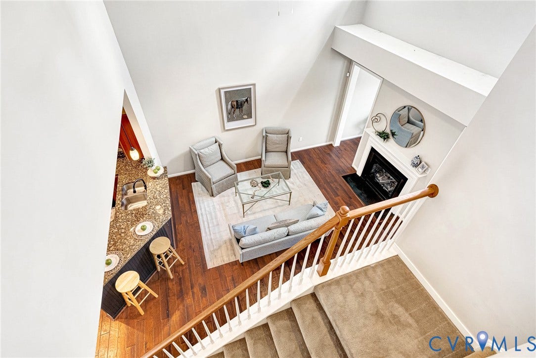 7728 Marshall Arch Drive, Liberty Trace, Mechanicsville, VA 23111 Vaulted ceilings, wood-finish flooring, staircase with wood banister, built-in fireplace, and an eat-in kitchen island with stone countertop