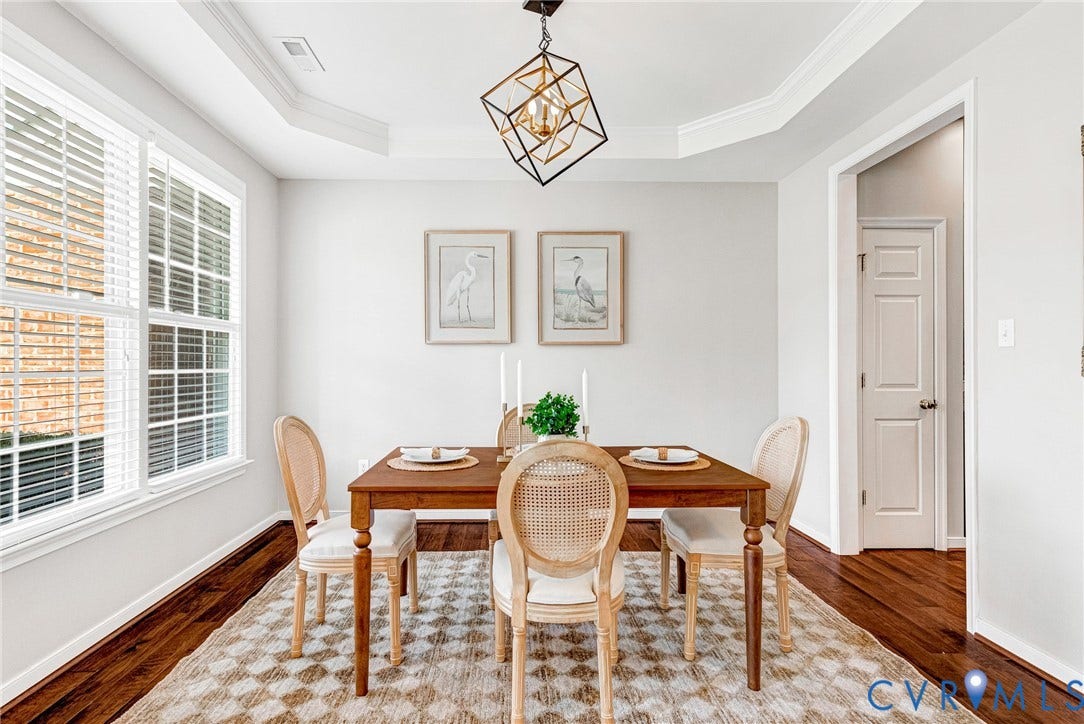 7728 Marshall Arch Drive, Liberty Trace, Mechanicsville, VA 23111 Tray ceiling with crown molding, geometric pendant light fixture, multiple windows with blinds, and rich wood-finish flooring