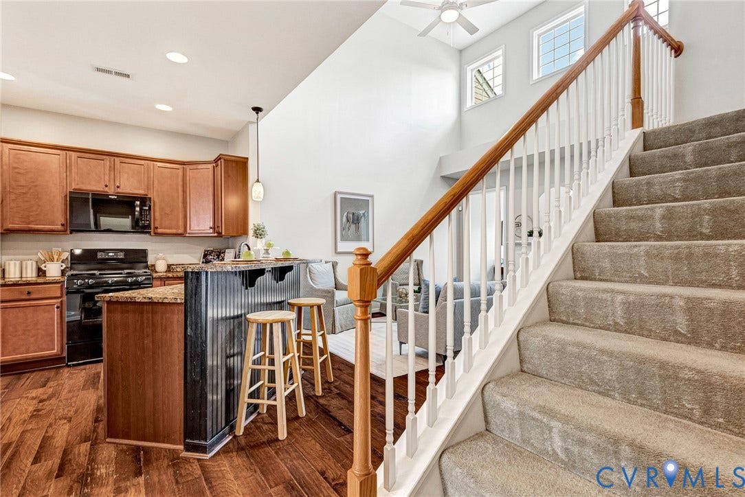 7728 Marshall Arch Drive, Liberty Trace, Mechanicsville, VA 23111 Kitchen featuring warm wood cabinetry, black appliances, and a breakfast bar with stone-look countertop