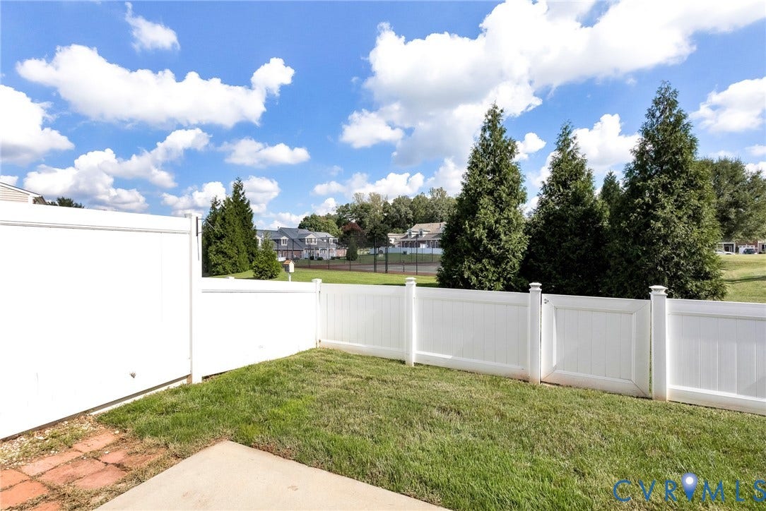 7728 Marshall Arch Drive, Liberty Trace, Mechanicsville, VA 23111 Enclosed backyard featuring a white privacy fence, concrete patio, and a brick paver pathway