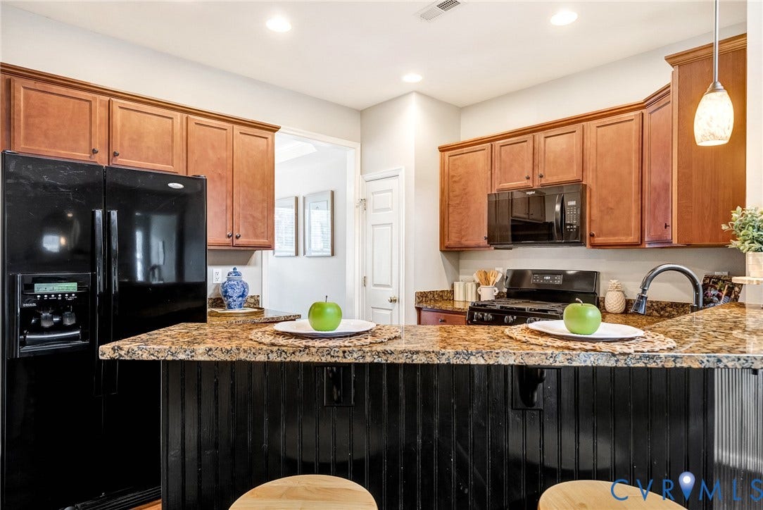 7728 Marshall Arch Drive, Liberty Trace, Mechanicsville, VA 23111 Kitchen featuring stone countertops, wood cabinetry, built-in microwave, black refrigerator, and black range