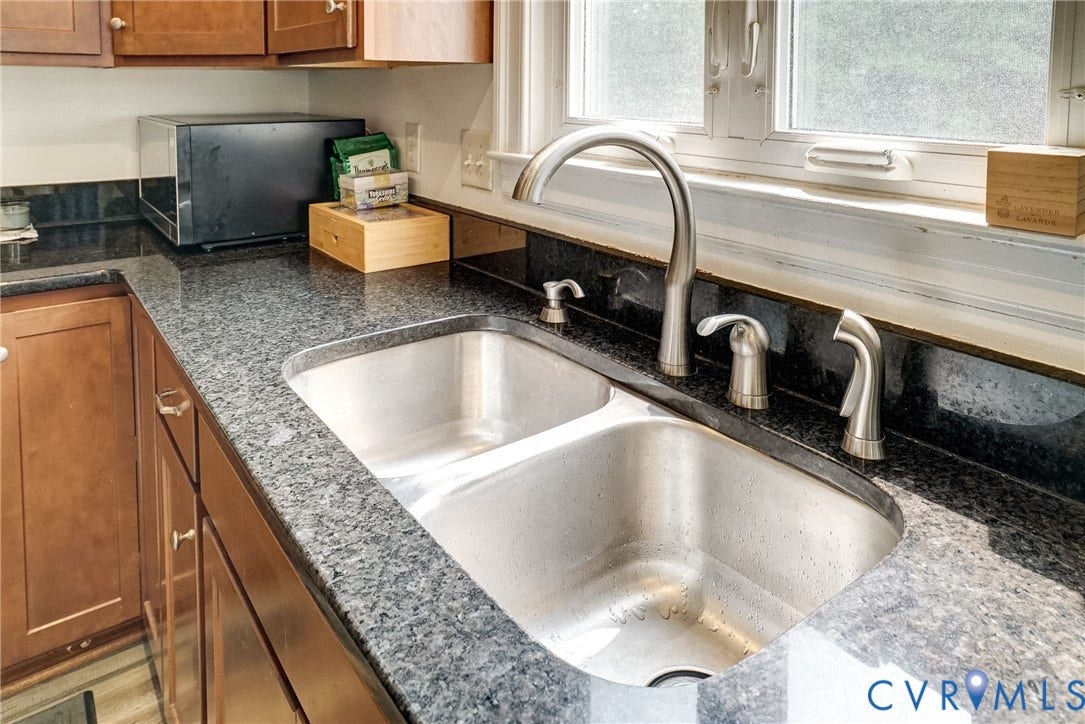 8805 Eli Place, Kings Forest, Glen Allen, VA 23060 Double basin stainless steel sink with a high-arch faucet, complemented by granite countertops and a matching backsplash