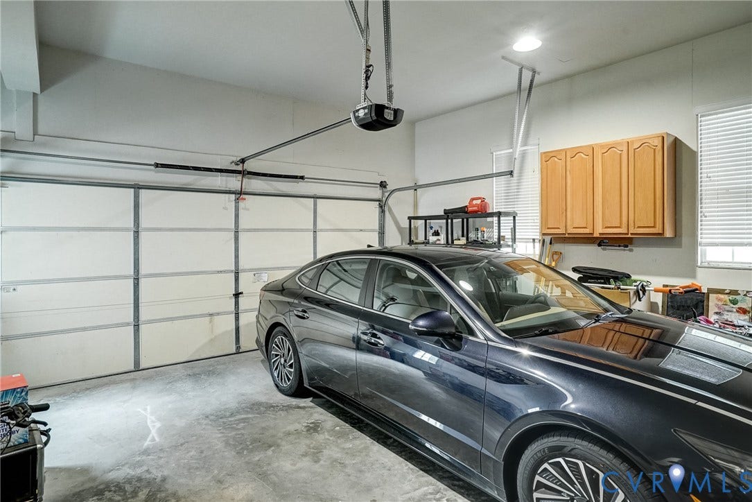 8805 Eli Place, Kings Forest, Glen Allen, VA 23060 Attached garage with an automatic door opener, concrete flooring, and built-in upper cabinetry