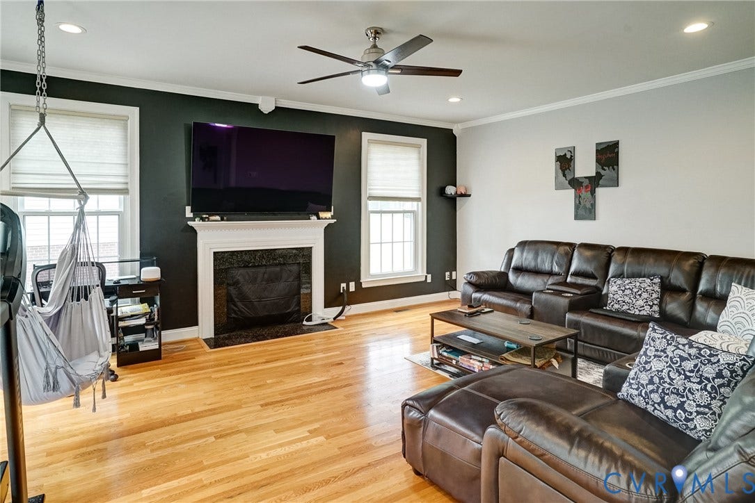 8805 Eli Place, Kings Forest, Glen Allen, VA 23060 Hardwood flooring throughout, a central fireplace with a mantel, recessed lighting, and a ceiling fan with integrated lighting
