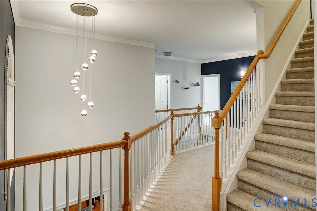 8805 Eli Place, Kings Forest, Glen Allen, VA 23060 Staircase with carpeted treads and wood handrail, featuring a contemporary spiral globe chandelier