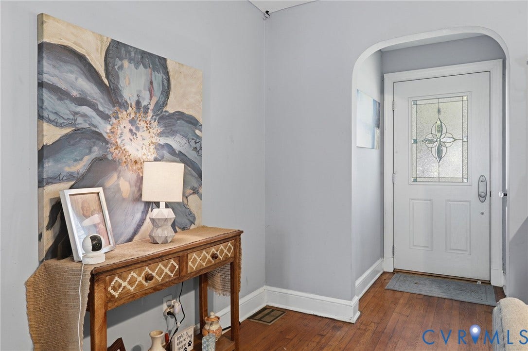 Arched entryway leading to a white panel door with decorative glass inlay