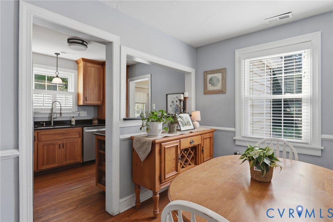 Kitchen with wood-finish cabinetry, black countertops, and a stainless steel dishwasher