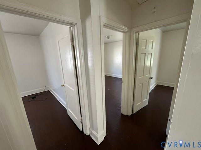 1227 Montgomery Avenue, Birdville Park, Petersburg, VA 23803 Three distinct doorways with solid panel doors, dark wood-finish flooring, and white painted walls