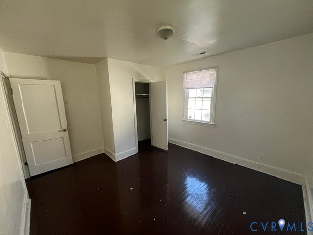 1227 Montgomery Avenue, Birdville Park, Petersburg, VA 23803 Rich wood-finish flooring, white painted walls, a single window with blinds, and a built-in closet