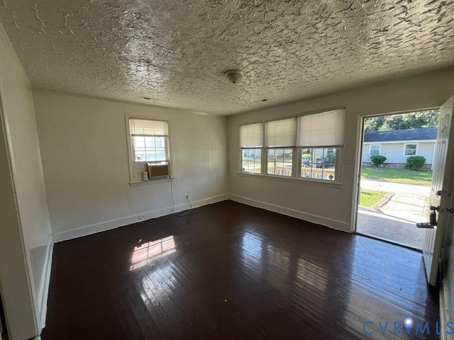 1227 Montgomery Avenue, Birdville Park, Petersburg, VA 23803 Hardwood flooring, painted paneled walls, multiple windows with blinds, and an exterior door